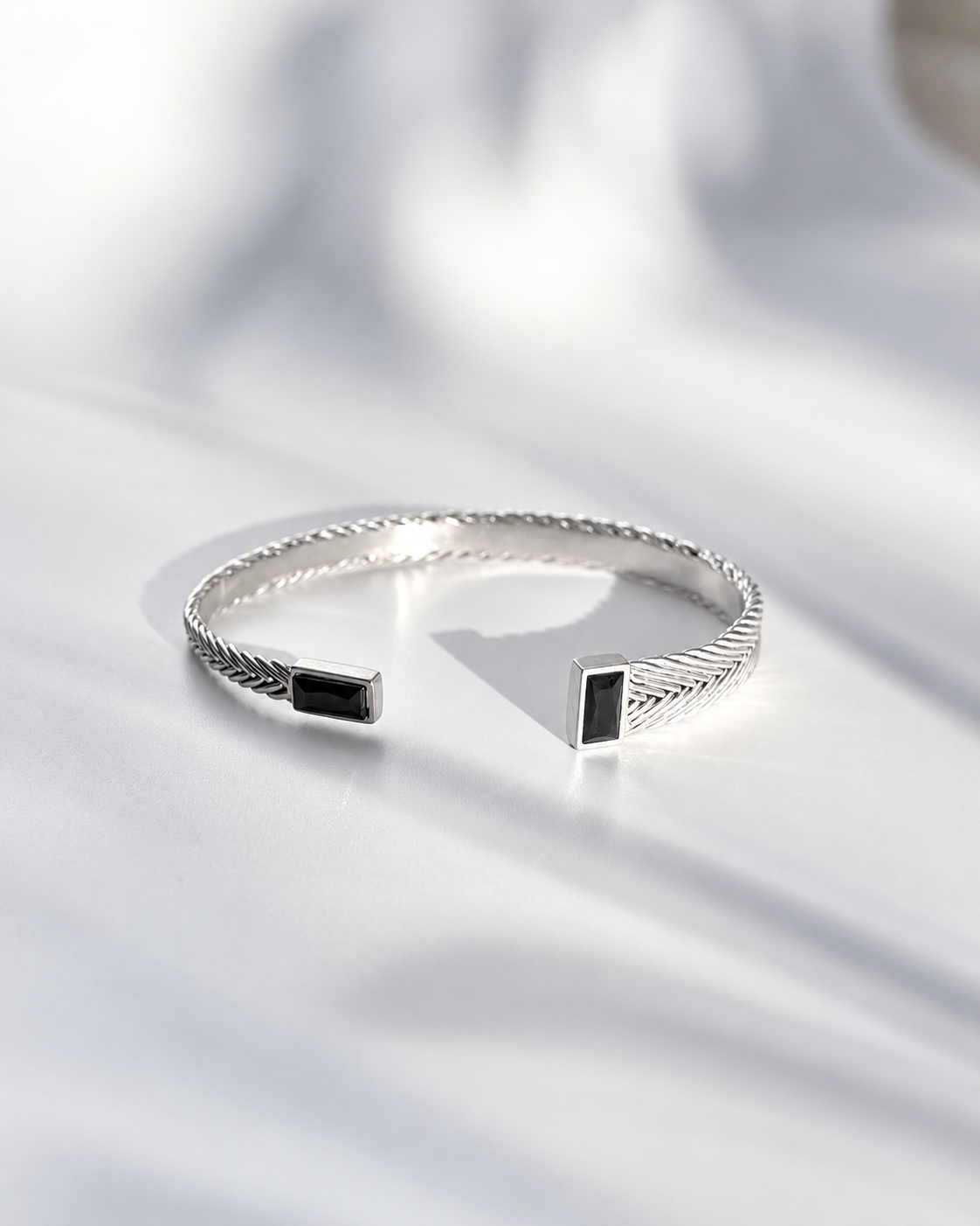 Hestia Woven Cuff in sterling silver with handwoven detail and black spinel stones in an asymmetrical sculptural form