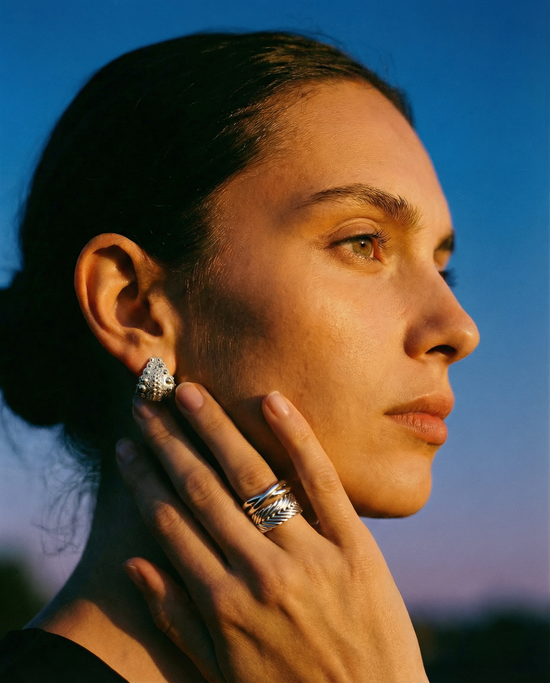 Model wearing handcrafted sterling silver Kefi Jewelry, featuring sculptural rings, earrings, and necklaces inspired by heritage, coastal textures, and everyday adornment.