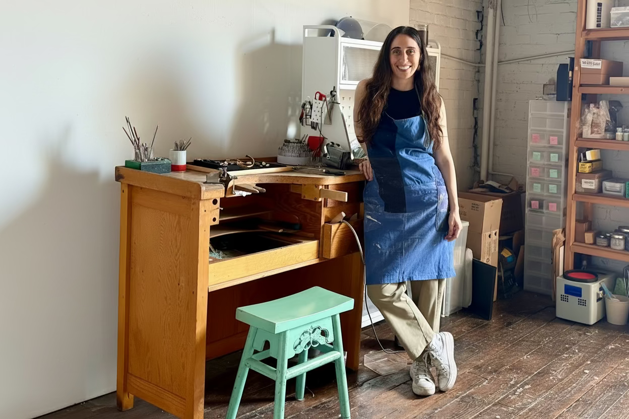 Jewelry designer Stephanie Alman working at her jewelry bench in her New York City studio, creating handcrafted Kefi Jewelry pieces inspired by heritage, coastal textures, and meaningful adornment.