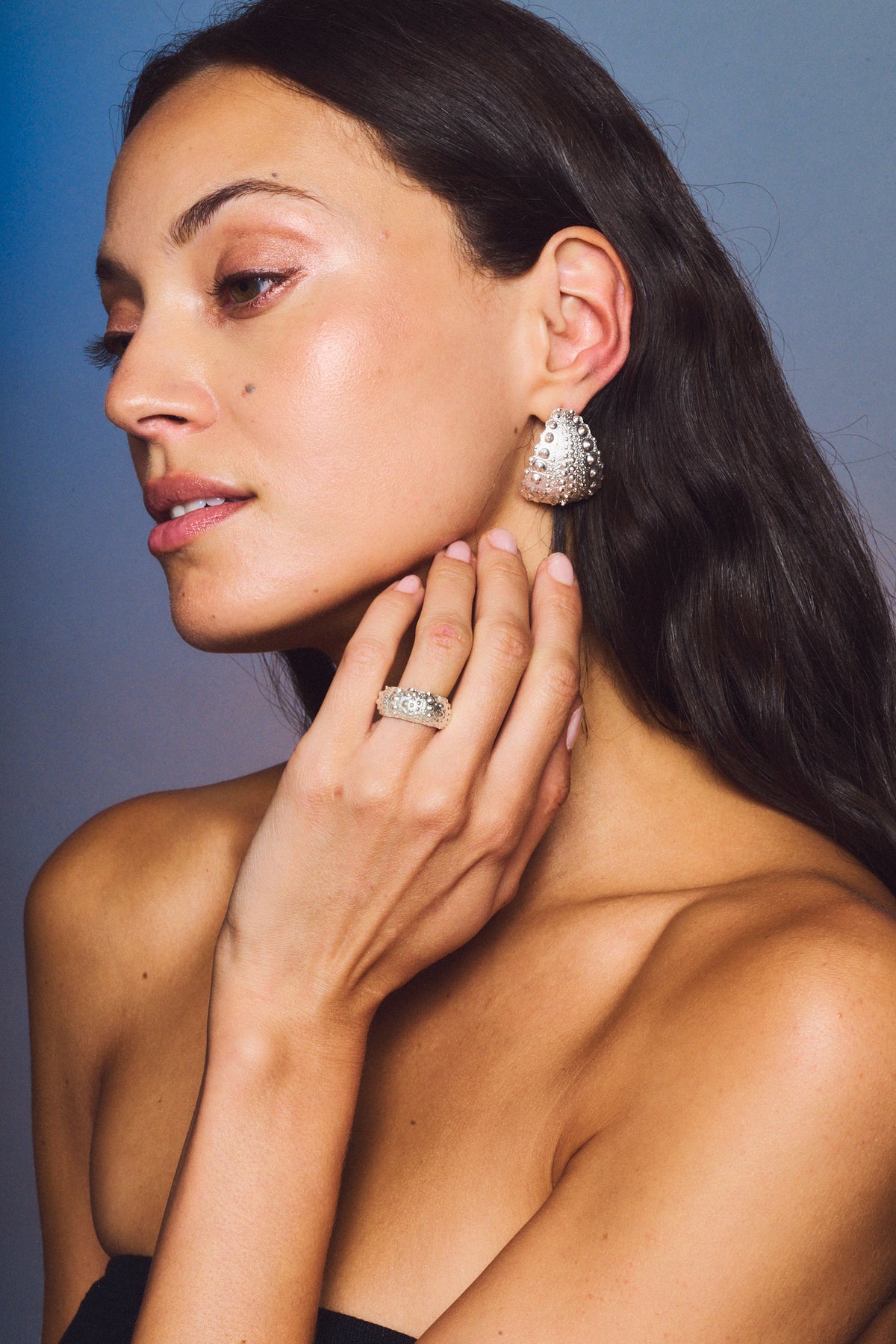 Model wearing Galatea Urchin Statement Earrings and a ring in sterling silver
