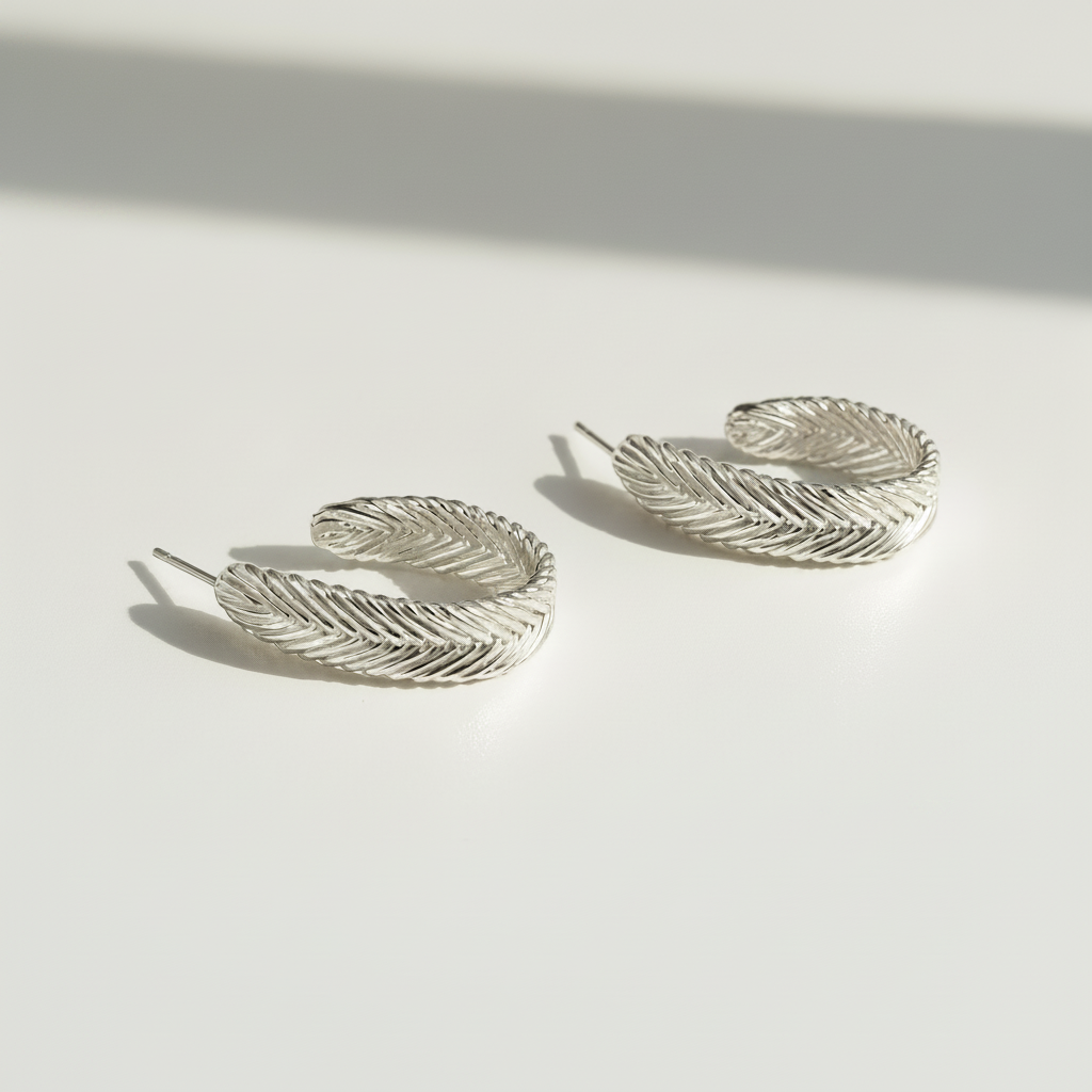 Sterling silver Harmonia Woven Hoop Earrings with handwoven herringbone texture by Kefi.