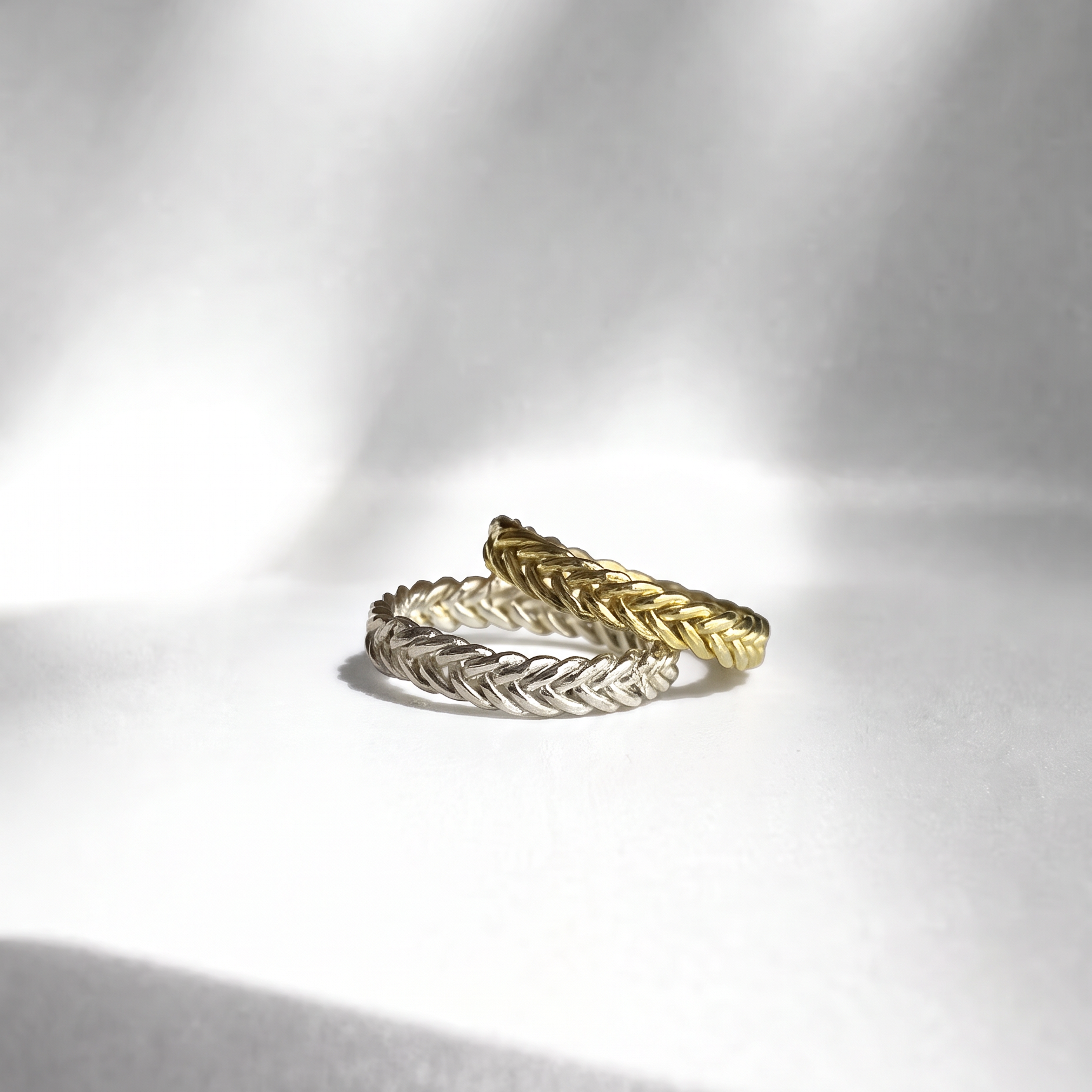 Two Hygeia Woven Rings stacked together, one in gold vermeil and one in sterling silver, showing the five-strand handwoven texture