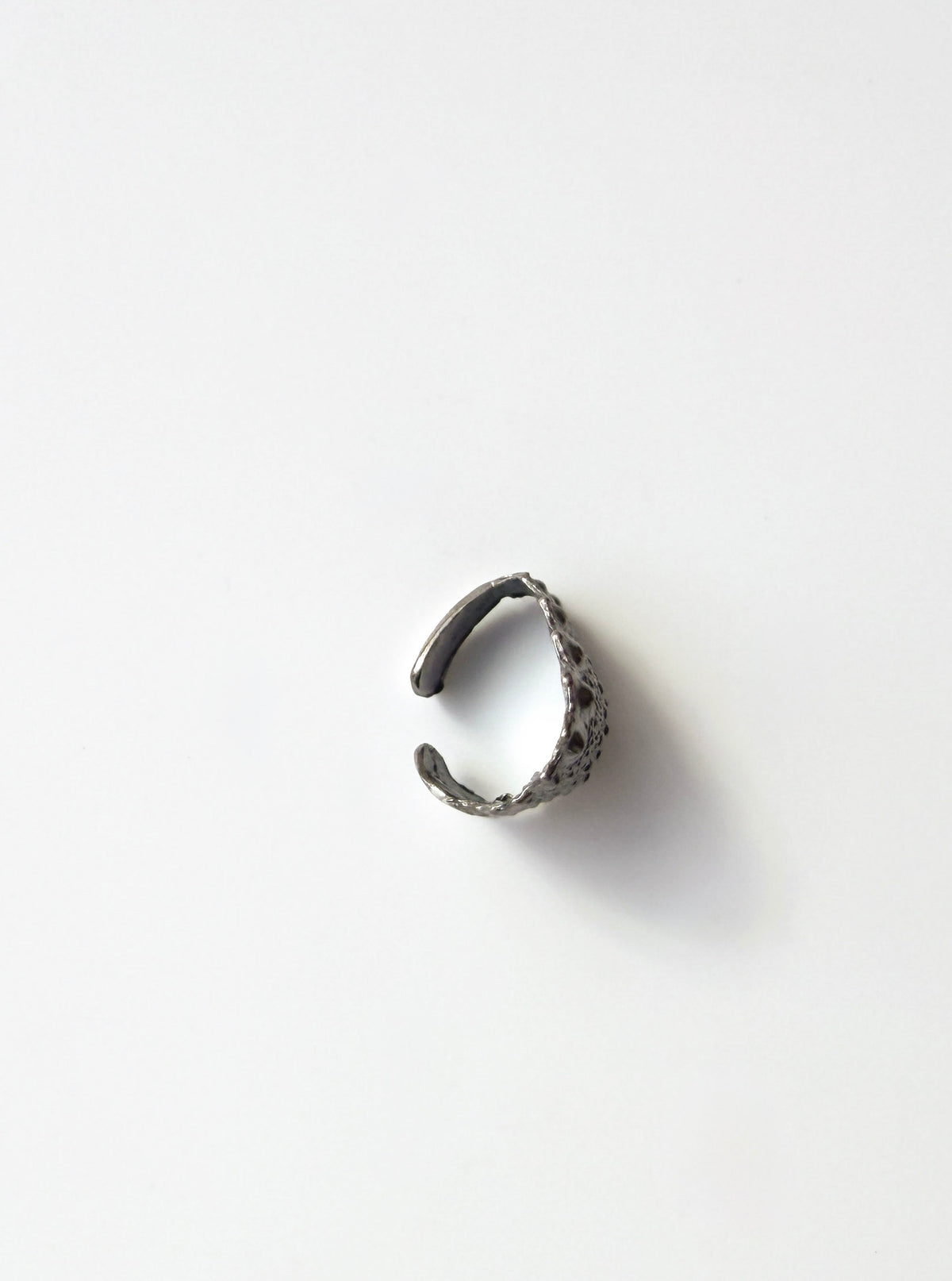 Side view of the Galatea Urchin Ear Cuff in oxidized sterling silver showing the open curve that follows the ear