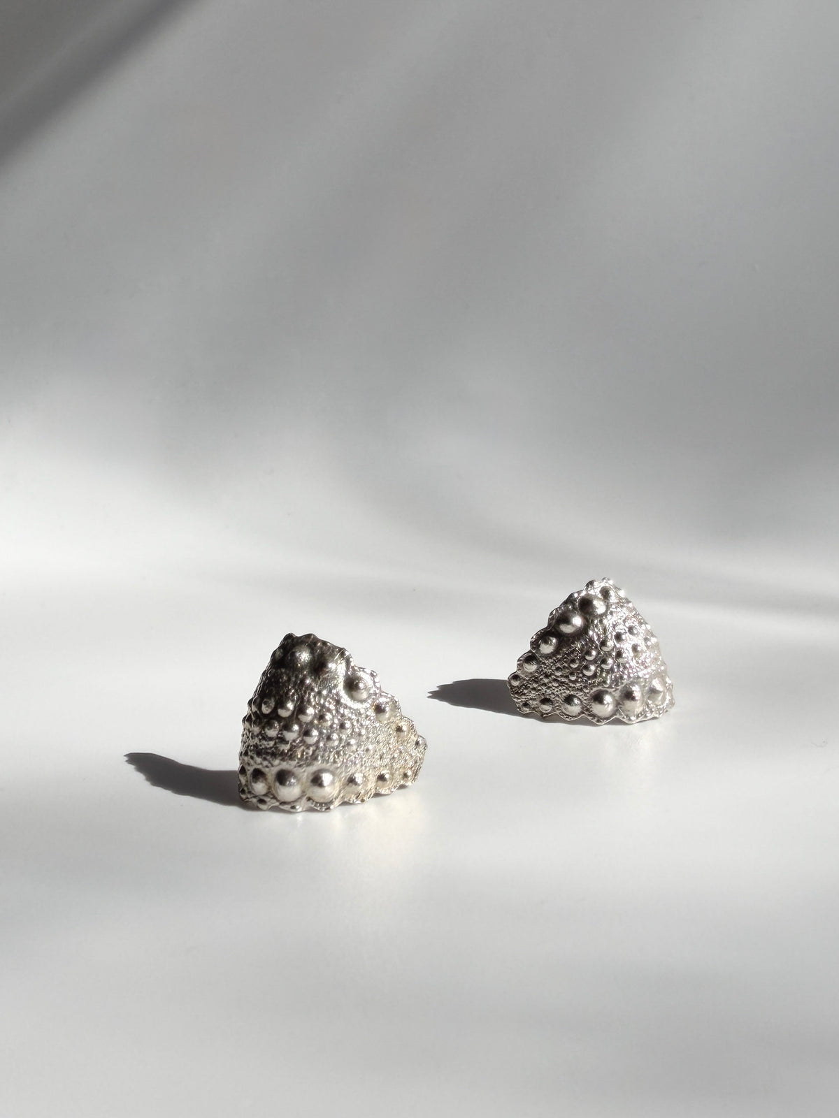 Galatea Urchin Hug Earrings in sterling silver, cast from a sea urchin shell, seen at an angle