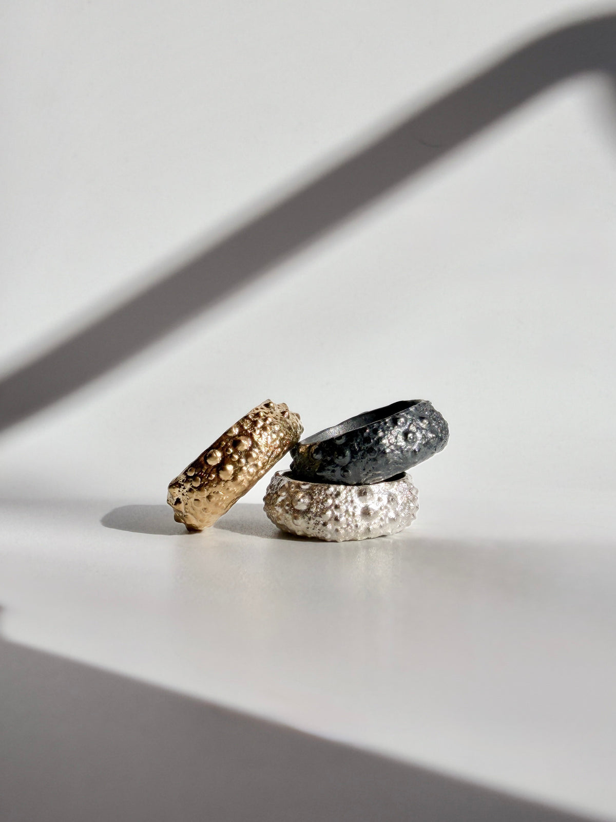 Galene Urchin Rings in gold vermeil, sterling silver, and oxidized sterling silver, stacking bands cast from a sea urchin shell