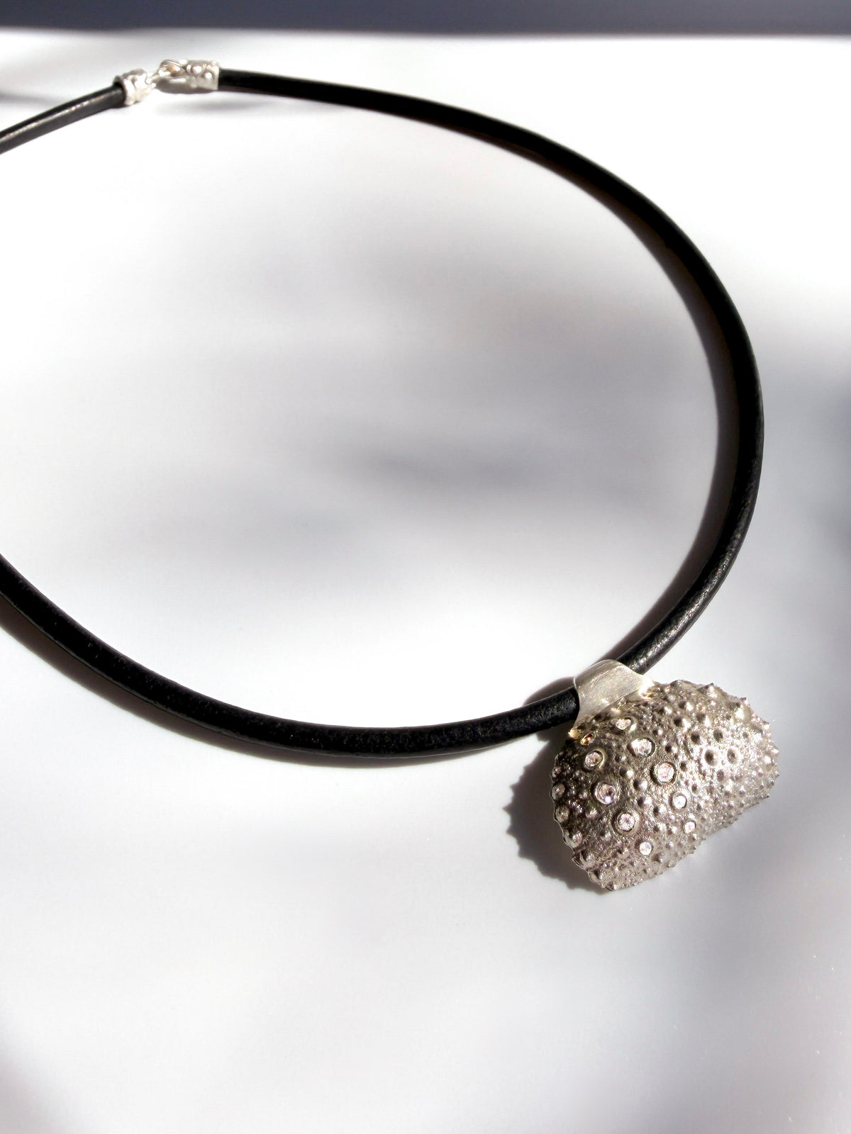 Thalassa Urchin Necklace in sterling silver, a pendant cast from a sea urchin shell on a black leather cord, handcrafted in New York City by Kefi