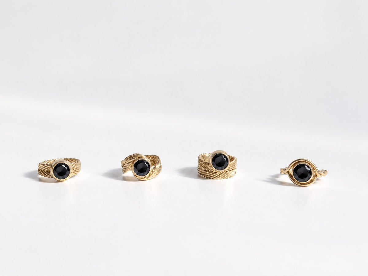 Four Woven Solitaire Rings in gold vermeil, each handwoven band set with a round black spinel, handcrafted in New York City by Kefi