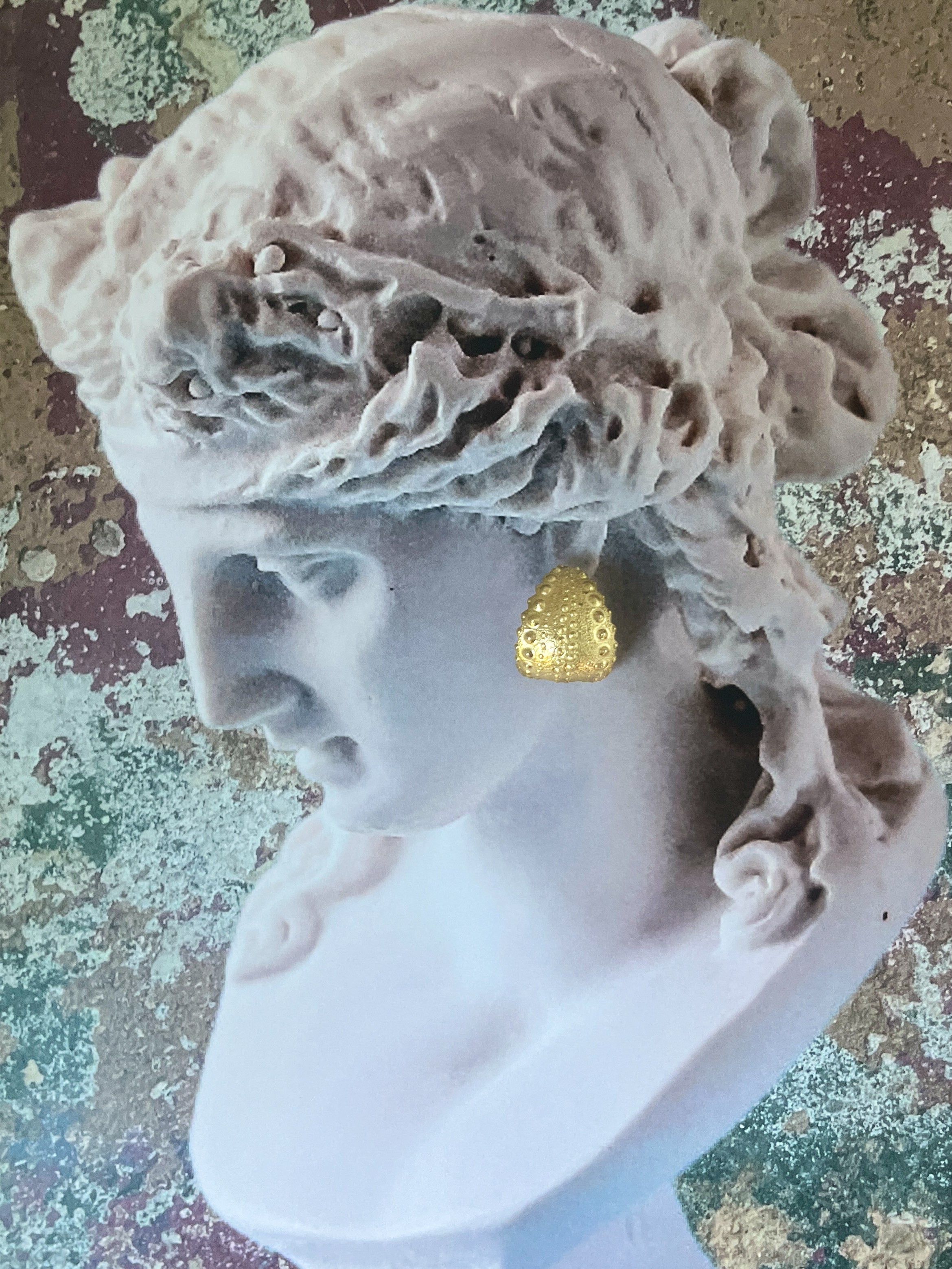 Bust wearing Urchin Hoop Earrings in gold vermeil, showcasing preserved sea urchin shell texture and timeless hoop design